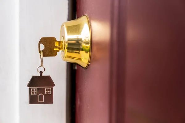 Chave da casa em um buraco de fechadura — Fotografia de Stock