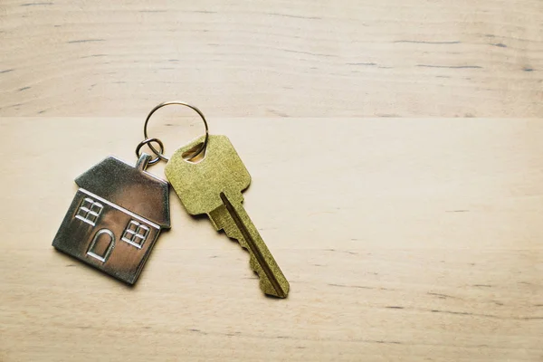 Ahşap arka planda ev anahtarı ve anahtarlık — Stok fotoğraf