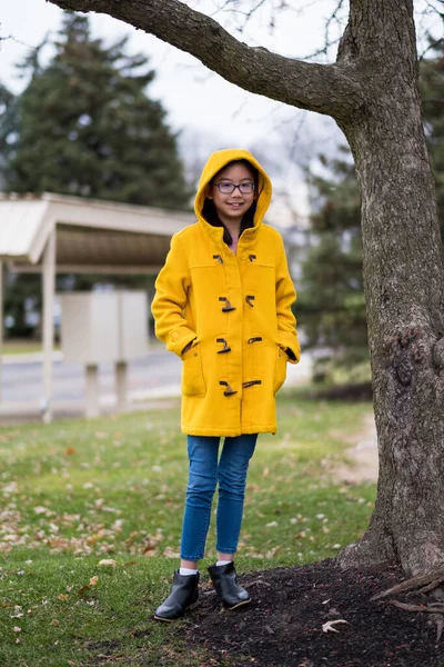 Азиатская девочка-подросток в желтом пальто — стоковое фото