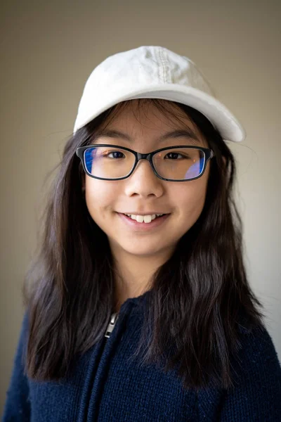 Portré ázsiai tini lány szemüveges és fehér sapka — Stock Fotó