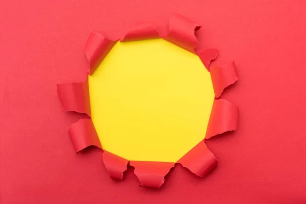 Papel rojo con agujero rasgado en el fondo medio —  Fotos de Stock