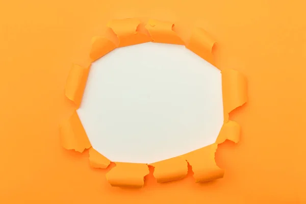 Orange paper with ripped hole in the middle background — ストック写真