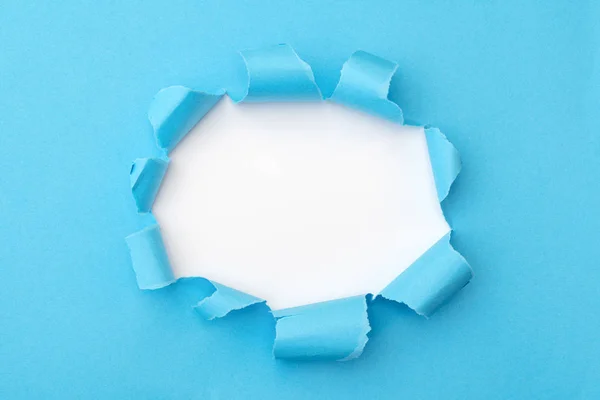 Blue paper with ripped hole in the middle background — 스톡 사진