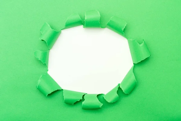 Orta arkaplanda yırtık deliği olan yeşil kağıt — Stok fotoğraf