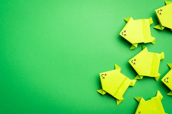 Bir grup origami yeşil kağıt kurbağa. — Stok fotoğraf