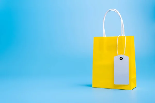 Yellow shopping or gift bag isolated on blue — 图库照片