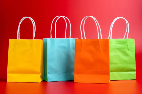 Compras coloridas ou sacos de presente isolados no vermelho — Fotografia de Stock