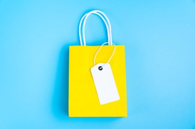 Yellow shopping or gift bag isolated on blue
