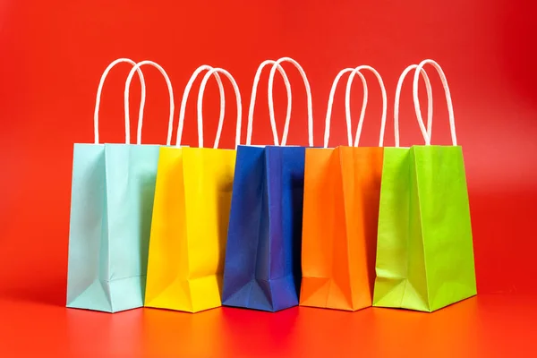 Compras coloridas o bolsas de regalo aisladas en rojo —  Fotos de Stock