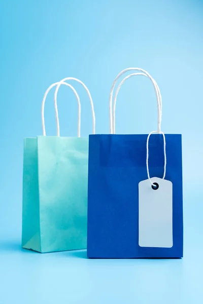 Two blue shopping or gift bags isolated on blue background — 图库照片