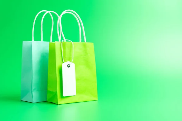 Two green shopping or gift bags isolated on green background — Stock Photo, Image