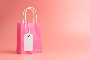 Single pink shopping or gift bag isolated on pink background