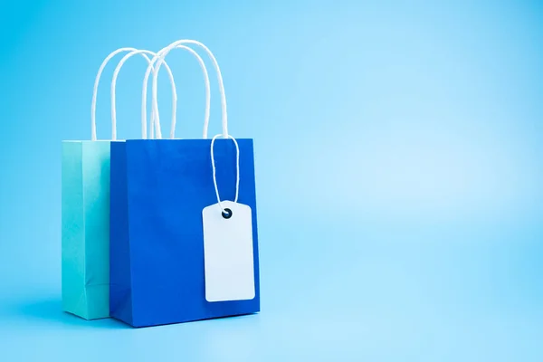 Two blue shopping or gift bags isolated on blue background — 图库照片
