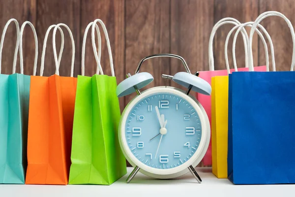 Relógio despertador e sacos de compras coloridos — Fotografia de Stock