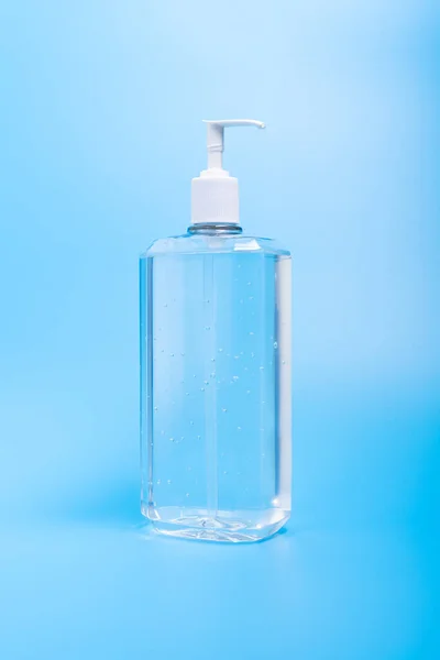 Χέρι απολυμαντικό σε πλαστικό μπουκάλι σε μπλε φόντο — Φωτογραφία Αρχείου