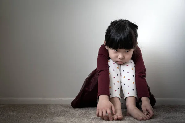 Solitaria niña triste sosteniendo sus rodillas —  Fotos de Stock