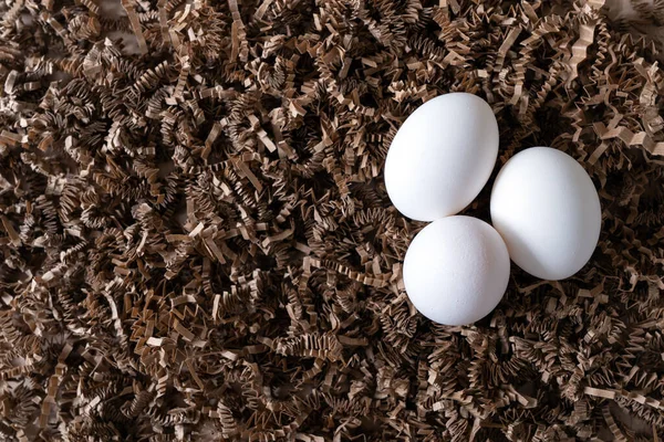 Drei weiße Hühnereier im Nest — Stockfoto