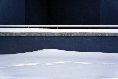 Kar ve mavi duvar. Kış kentsel arka plan.          