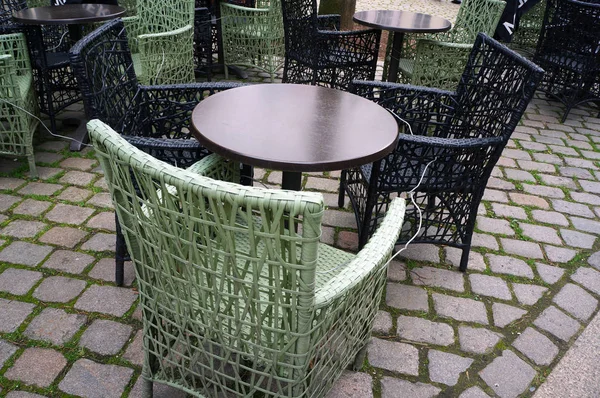 Café mesas de círculo y sillas de mimbre en la calle pavimento . —  Fotos de Stock