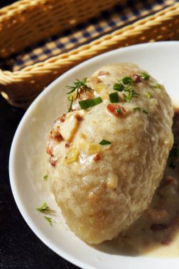 Sos soslu Cepelinai (zeplin), çıtırtı ve yeşillik - dereotu ve yeşil soğan. Geleneksel Litvanya yemekleri. Seçici odak.