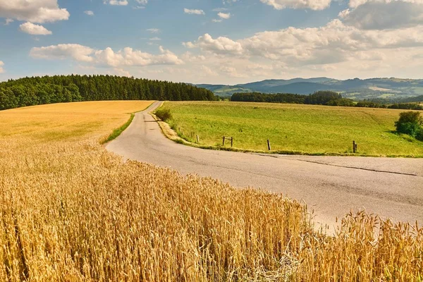 Estrada através de terras agrícolas — Fotografia de Stock