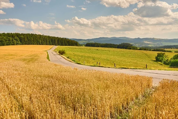 Estrada através de terras agrícolas — Fotografia de Stock