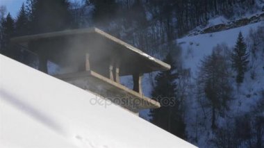 Sigara baca karlı bir çatı üzerinde