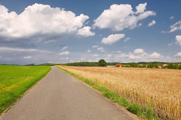Estrada através de terras agrícolas — Fotografia de Stock