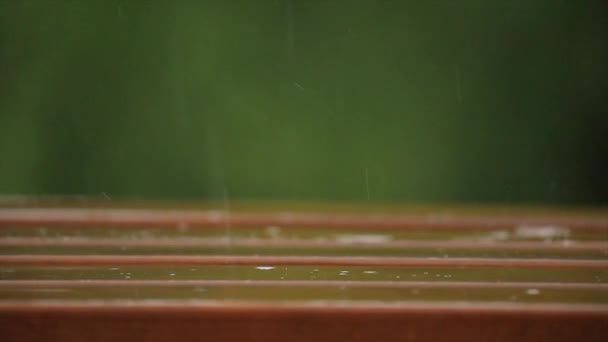 Llueve sobre una mesa de parque — Vídeos de Stock