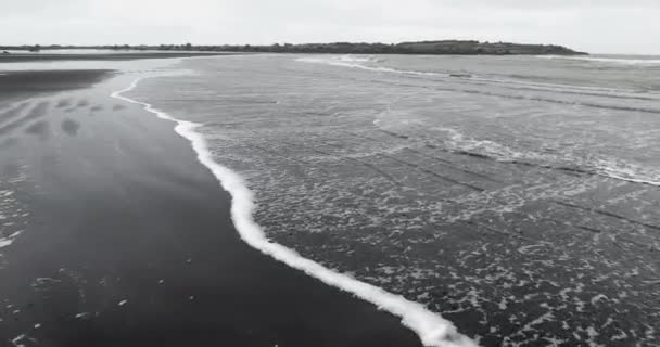 Playa de arena negra olas tranquilas — Vídeo de stock