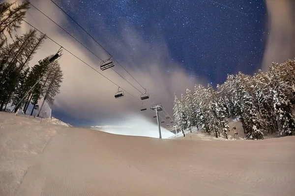 Ski lift at night under the stars in the sky