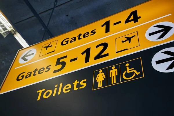 Toilet and gates signs showing direction — Stock Photo, Image