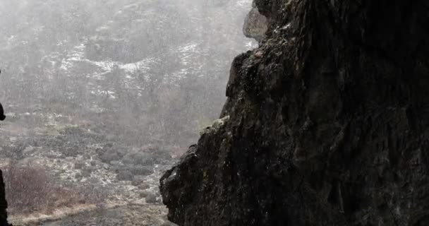 Fallender Schnee in einem Tal, Unterschlupf in einer Höhle — Stockvideo