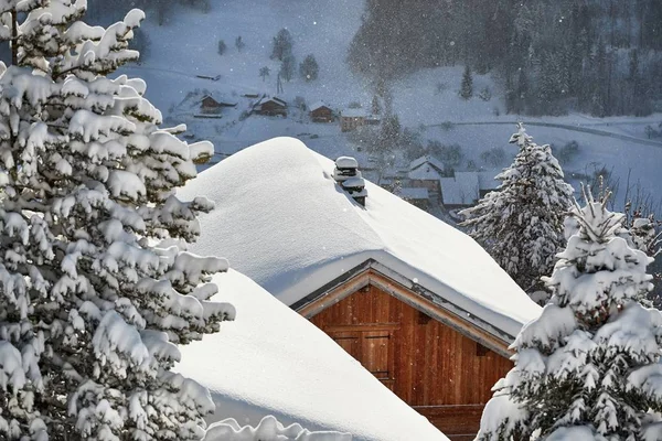 Zimowa wioska górska, dach i komin pokryte śniegiem — Zdjęcie stockowe