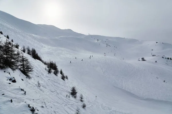 Lyžařské sjezdovky, zasněžená alpská krajina — Stock fotografie