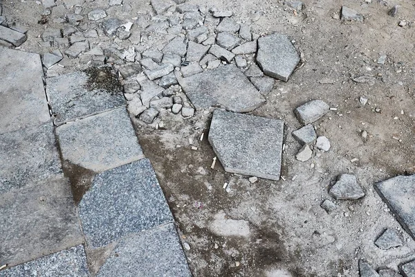 Pavimento de pedra quebrado perto da construção — Fotografia de Stock