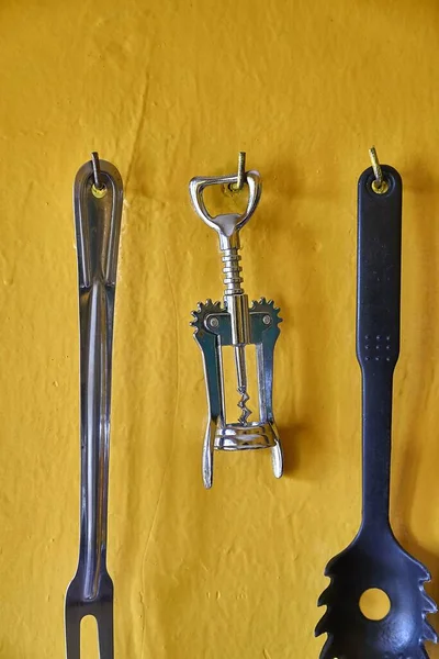 Corkscrew and othe utensils on a kitchen wall — Stock Photo, Image