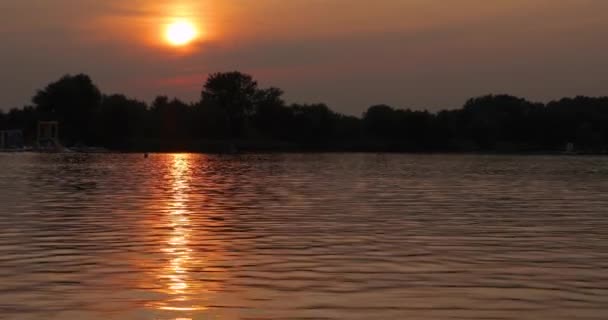 Solnedgång över en lugn sjö — Stockvideo