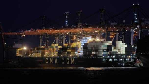 Containers laden op een schip in het donker — Stockvideo