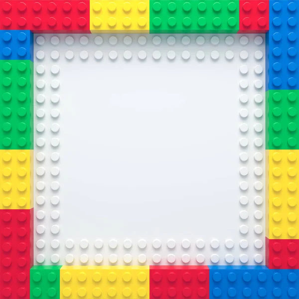 Frame of colorful toy bricks on white construction plate — Stock Photo, Image