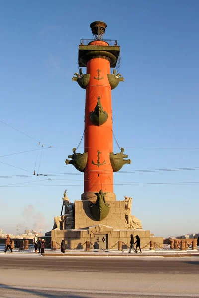 People walk near the Rostral columns in Saint-Petersburg. — Stock Photo, Image