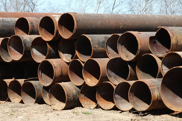 Las tuberías oxidadas de gran diámetro almacenadas en el suelo . —  Fotos de Stock