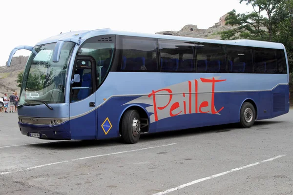 Ein dunkelblauer Touristenbus steht auf einer Asphaltfläche vor dem Haus. lizenzfreie Stockfotos