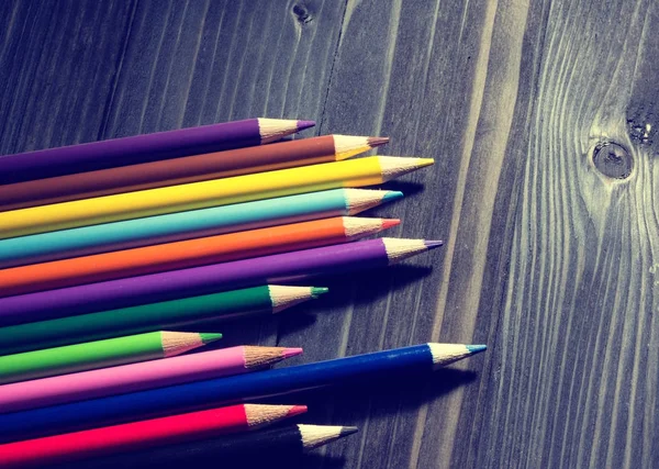 Lápices coloreados sobre mesa negra —  Fotos de Stock