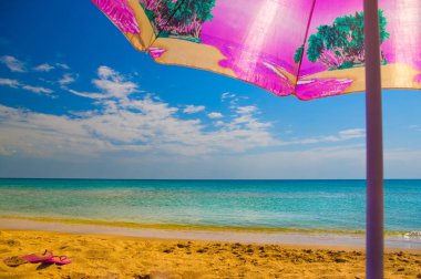 Sahilde bir şemsiye altında dinlenmek.