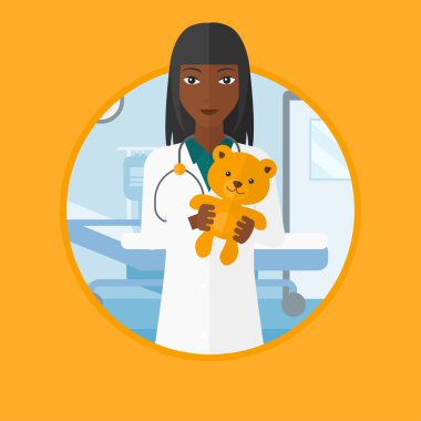 Çocuk doktoru doktor holding oyuncak ayı.