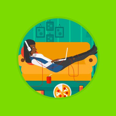 Birçok gadget'lar ile kanepede yatan kadın.