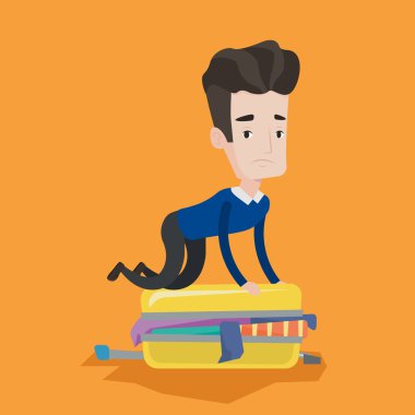 Genç adam bavul kapatmaya çalışırken.