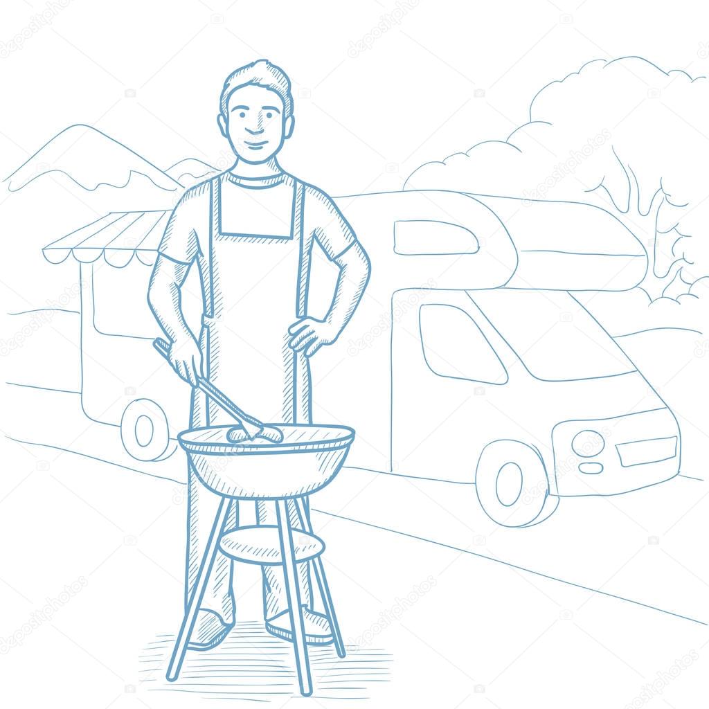 Man having barbecue in front of camper van.