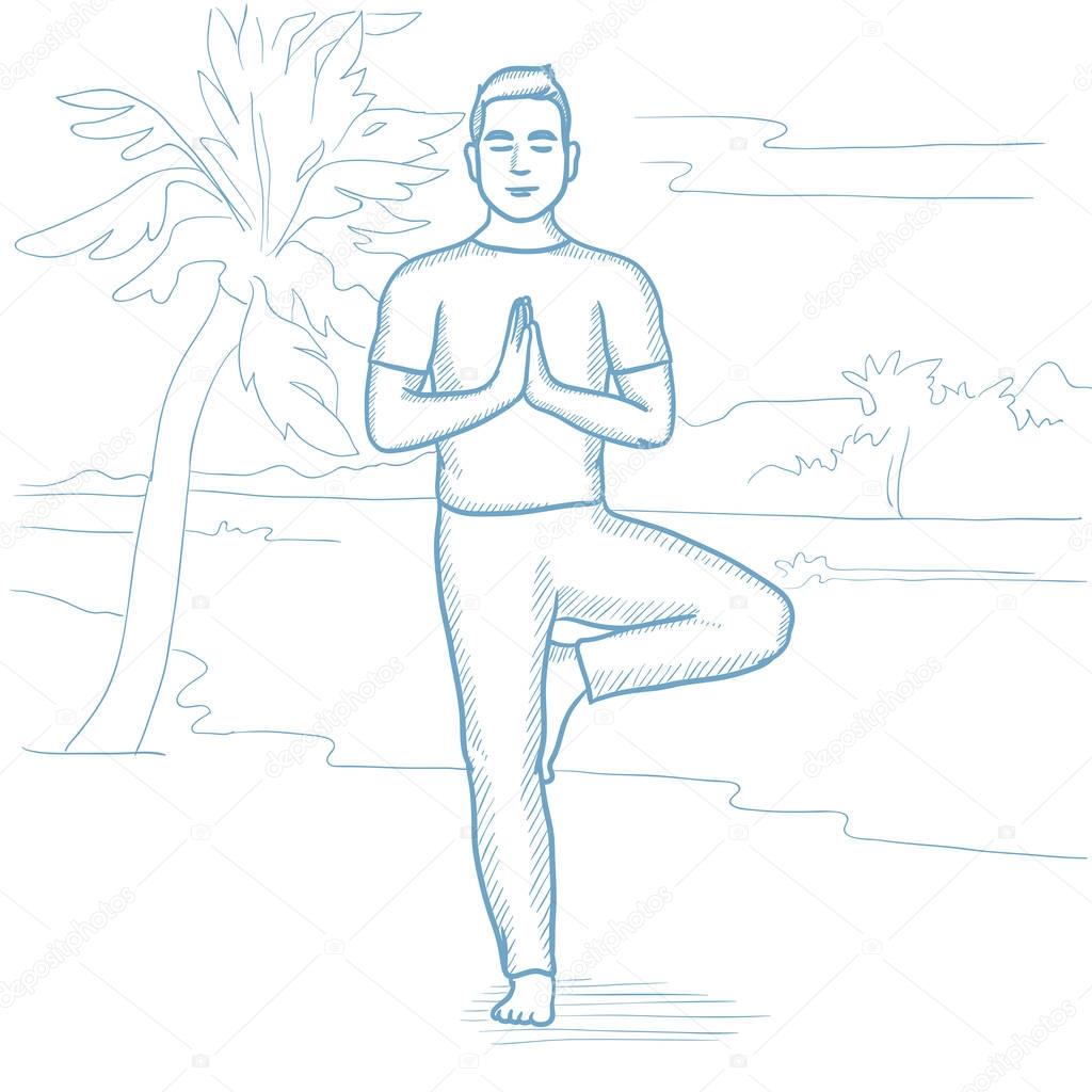 Man practicing yoga on the beach.